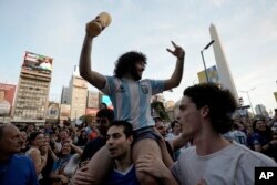 Argentina soccer fans celebrate their team's victory over Croatia after watching the team's World Cup semifinal match in Qatar on TV in downtown Buenos Aires, Argentina, Dec. 13, 2022.