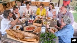 FILE - Diego Guerrero, from left, Carlos Sanchez, Mila, Ines Andres, Carlota Andres, Jose Andres and Pepa Muñoz enjoy a meal in a scene from the Discovery + television series "Jose Andres and Family in Spain." (Xaume Olleros/Discovery via AP)