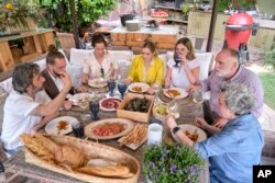 Diego Guerrero, from left, Carlos Sanchez, Mila, Ines Andres, Carlota Andres, Jose Andres and Pepa Muñoz enjoy a meal in a scene. (Xaume Olleros/Discovery via AP)