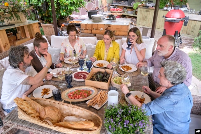 Diego Guerrero, from left, Carlos Sanchez, Mila, Ines Andres, Carlota Andres, Jose Andres and Pepa Muñoz enjoy a meal in a scene. (Xaume Olleros/Discovery via AP)