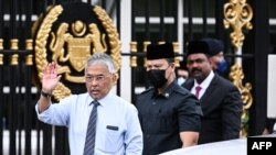 Raja Malaysia Sultan Abdullah Sultan Ahmad Shah (kiri) melambaikan tangan saat bertemu dengan media di luar Istana Nasional di Kuala Lumpur, 21 November 2022. (Mohd RASFAN / AFP)