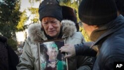 The mother of writer Volodymyr Vakulenko mourns near his grave on Dec. 6, 2022, after he died during the Russian occupation of Kharkiv, Ukraine. The U.S. Congress is considering the White House’s request to give Ukraine $38 billion more in aid to defend itself against Russia.