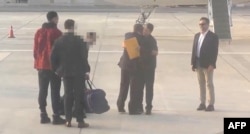 FILE - This video grab taken from a footage shown by Russian state media purports to show U.S. basketball star Brittney Griner, left, during a prisoner swap with Viktor Bout, a notorious Russian arms dealer, second-right, on the tarmac of Abu Dhabi airport, Dec. 8, 2022.