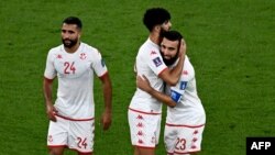 Le défenseur tunisien n°24 Ali Abdi, le milieu de terrain tunisien n°13 Ferjani Sassi et l'attaquant tunisien n°23 Naim Sliti célèbrent leur match nul après le match de football du groupe D de la Coupe du monde Qatar 2022 entre le Danemark et la Tunisie.