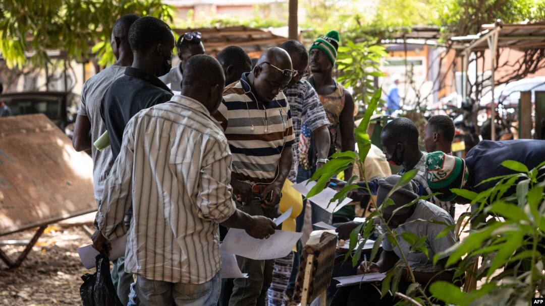 FILE - Men stand in line with their application letters to enroll as Volunteers for the Defense of the Fatherland (VDP), at the Governorate of Ouagadougou, Burkina Faso, Nov. 16, 2022.
