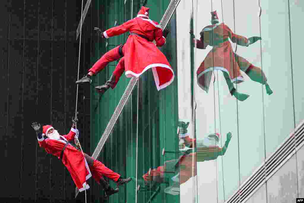 Climbers dressed as Santa Claus climb the building of the peadiatric clinic of the Ljubljana University Medical Centre in Ljubljana, Slovenia.