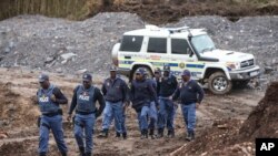 South African police investigate at the scene where more than 20 bodies, suspected of being illegal miners, were found near an active mine in Krugersdorp, South Africa, Nov. 3, 2022.