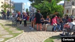 Personas esperan en un parque cercano a la Embajada de EEUU en La Habana para entrar a sus entrevistas, en el primer día del reinicio del trámite de visados de inmigrante después de cinco años, el 4 de enero de 2022.