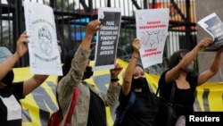 Demonstrators hold up signs during a protest as lawmakers get set to amend Indonesia's penal code, outside the Parliament building in Jakarta, Dec. 5, 2022.