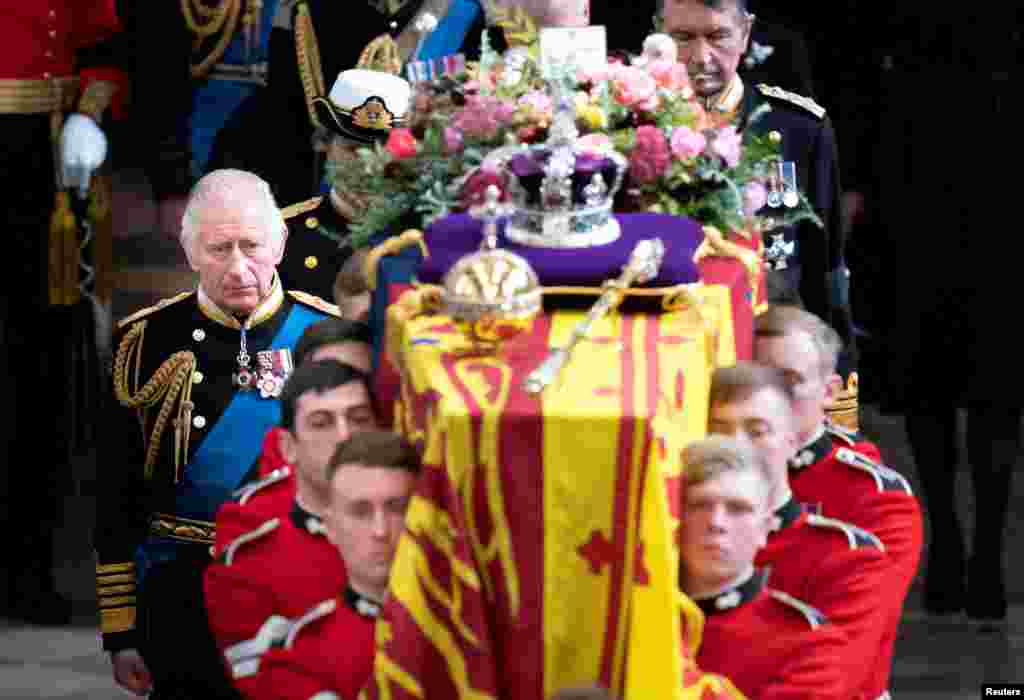 El rey Carlos de Inglaterra y miembros de la familia real acompañan el féretro de la reina Isabel II de Inglaterra, cubierto con el Estandarte Real, la Corona Imperial y el orbe y el cetro de la soberana, mientras es llevado fuera de la Abadía de Westminster después de su funeral de Estado, Londres, Reino Unido, el 19 de septiembre de 2022.
