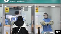 A health worker takes a nasal swab from a traveler arriving from China at a COVID-19 testing center at Incheon International Airport, west of Seoul on Jan. 3, 2023. 