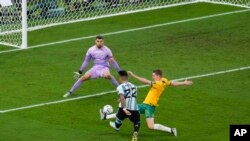 Argentina's Lautaro Martinez, left, shoots the ball next to Australia's Kye Rowles, right, and Australia's goalkeeper Mathew Ryan during the World Cup round of 16 soccer match between Argentina and Australia at the Ahmad Bin Ali Stadium in Doha, Qatar, Dec. 3.