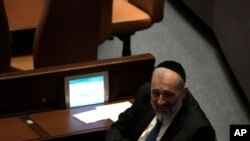 FILE - Israeli lawmaker Aryeh Deri visits with a colleague during a vote on Levin as Speaker of the Knesset, Israel's parliament, in Jerusalem, Dec. 13, 2022. 