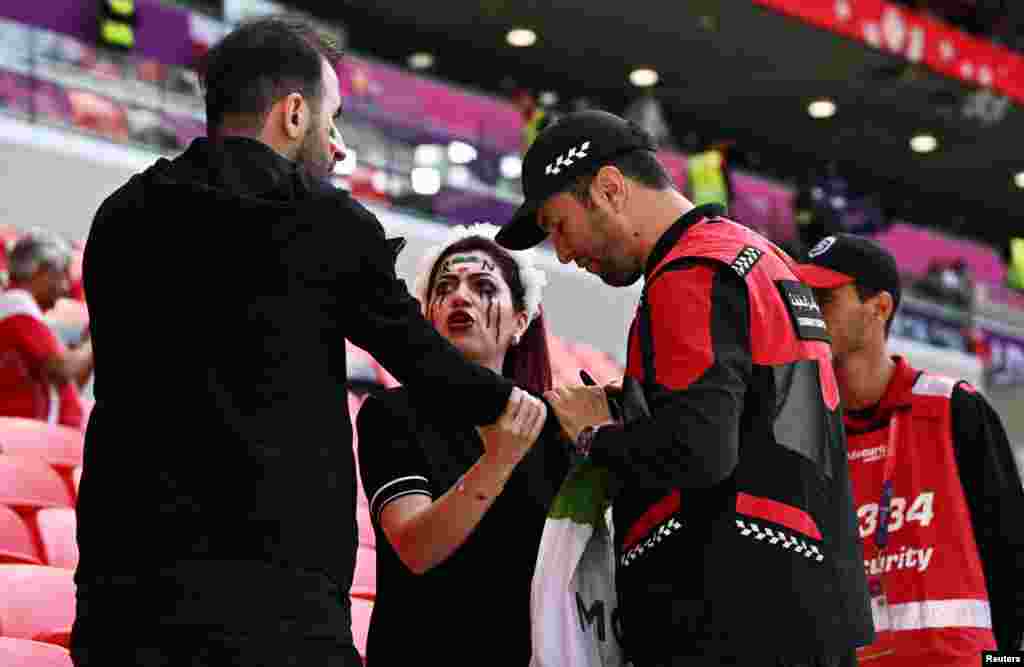 Police officers confiscate an Iranfan&#39;s &#39;Women Life Freedom&#39; Iran flag before the Group B soccer match between Wales and Iran at the Ahmad Bin Ali Stadium in Al Rayyan, Qatar, Nov. 25, 2022.