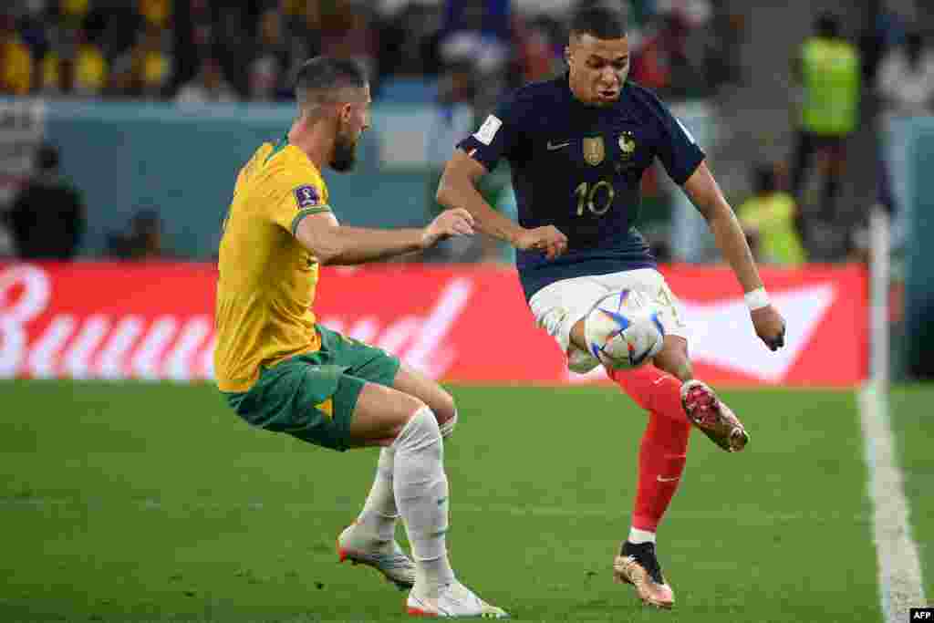 Kyllian Mbappé #10 ya France (D) azali kopusa ndembo liboso lya mabateli to défenseur ya Australie #02 Milos Degenek na match ya groupe D ya Mondial Qatar 2022, na stade Al-Janoub, Al-Wakrah, Doha, 22 novembre 2022. (Photo FRANCK FIFE / AFP)