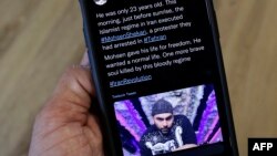 手机屏幕上显示莫森·谢卡里（Mohsen Shekari）的照片与他被伊朗当局处死的推文。（2022年12月8日）