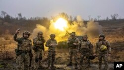 Ukrainian servicemen pose for a photo during the shoot towards Russian forces of self-propelled artillery at a frontline in Kharkiv region, Ukraine, Dec. 24, 2022.