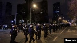 Aparat keamanan turun dalam menanggapi protes terhadap pembatasan COVID-19 di Beijing, China, 28 November 2022. (Foto: REUTERS/Thomas Peter)