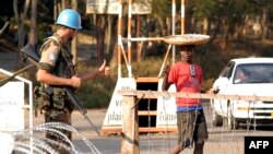 ARCHIVES - Un Casque bleu uruguayen salue un garçon congolais le 7 juin 2004: les "intermédiaires" étaient souvent des jeunes garçons qui venaient "rôder autour du camp" et faisaient office de garçons de courses pour les militaires.