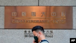 資料照 - 一名路人走過中國恆大香港總部大樓。美聯社照片。2021年10月4日。