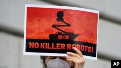 A woman holds up a sign while taking part in a demonstration about the use of robots by the San Francisco Police Department outside of City Hall in San Francisco, Monday, Dec. 5, 2022. (AP Photo/Jeff Chiu)