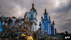 Construction workers climb onto the roof of a destroyed church in the village of Bohorodychne, Donetsk region, Ukraine, on Jan. 4, 2023, amid the Russian invasion of Ukraine.
