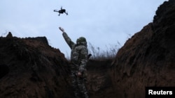 Украинский военный запускает дрон в районе Бахмута