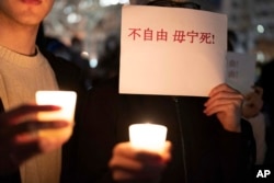 在美国首都华盛顿白宫附近举行抗议的人群手举反对中国政府严厉防疫政策的标语。（2022年12月4日）