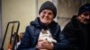 Жительница украинского Бахмута со своим котом спасается от российского обстрела в центре помощи населению в Рождественский сочельник
