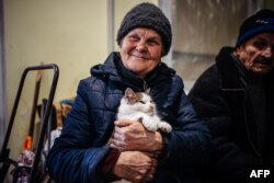 A local resident holds her cat in a humanitarian aid center in Bakhmut, Donetsk region, Jan. 6, 2023. Holdout residents of the all-but-destroyed city have flocked to the center, desperate for food and internet access amid the Russian invasion of Ukraine.