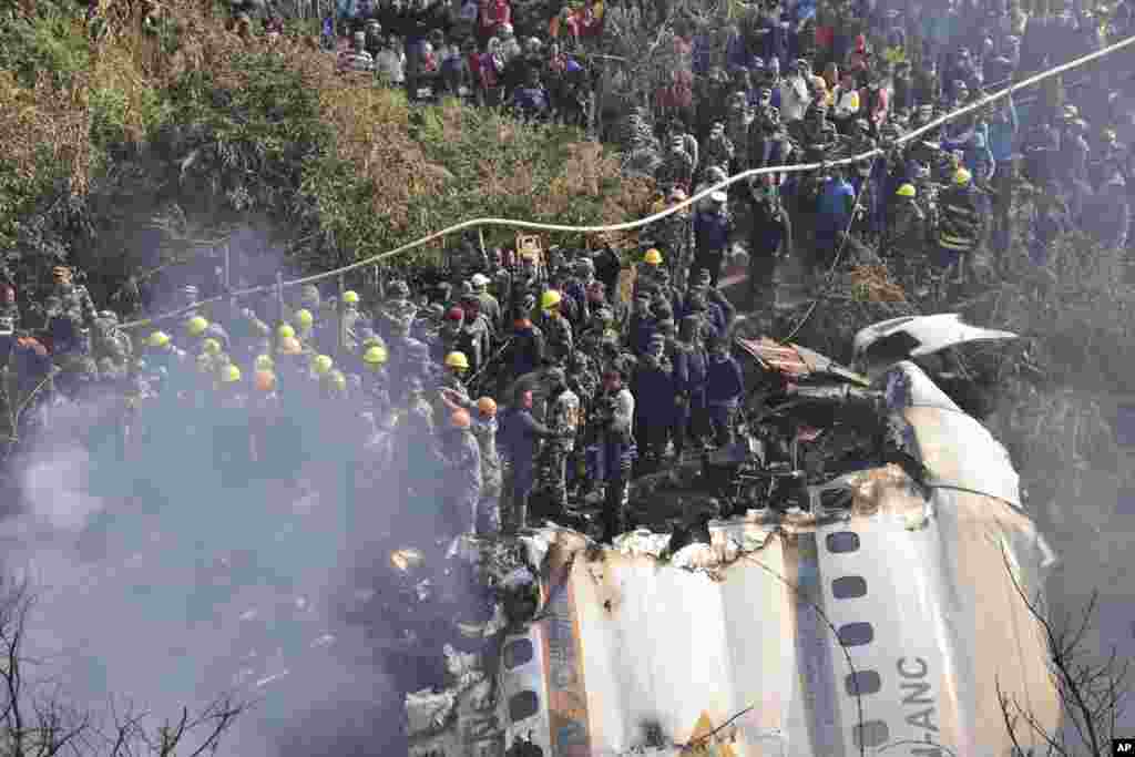 Rescue workers and civilians gather around the wreckage of a passenger plane that crashed in Pokhara, Nepal.&nbsp;Authorities said 68 people have been confirmed dead after a regional passenger plane with 72 aboard crashed into a gorge while landing at a newly opened airport in the resort town of Pokhara.