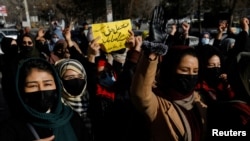 FILE - Afghan women chant slogans to protest the closure of universities to women by the Taliban, in Kabul, Dec. 22, 2022.