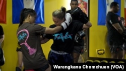 Stamp Fairtex, Thai female fighter, demonstrates a Muay Thai technique to a participant at T.A.G. Muay Thai in Virginia, October, 2022.