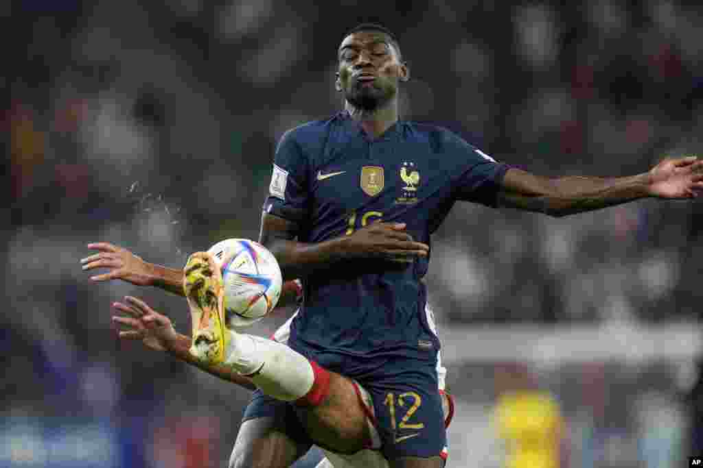 France&#39;s Randal Kolo Muani, right, fights for the ball with Tunisia&#39;s Mohamed Ali Ben Romdhane during the World Cup group D soccer match between Tunisia and France at the Education City Stadium in Al Rayyan, Qatar.