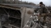 A Ukrainian soldier stands on the roof of a university damaged in a recent missile attack, in Kramatorsk Ukraine, Dec. 13, 2022. 