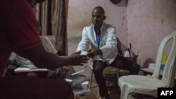 A doctor gives condoms and lubricants to a community member in a room behind the cinema in Yaounde, Cameroon on October 2, 2019.