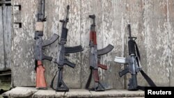 ARCHIVO - Las armas de los rebeldes del Ejército Marxista de Liberación Nacional (ELN) de Colombia se apoyan contra la pared de la casa de un agricultor, en las selvas del noroeste de Colombia, en agosto de 2017. 