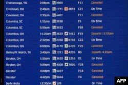 Papan elektronik di Terminal 1 United Airlines di Bandara Internasional O'Hare, Chicago, menunjukkan penundaan dan pembatalan penerbangan, 22 Desember 2022. (KAMIL KRZACZYNSKI/AFP)