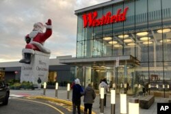Sinterklas (Big Santa) menyambut para pengunjung pusat perbelanjaan Westfield Garden State Plaza di Paramus, New Jersey, 17 Desember 2022. (AP Photo/Ted Shaffrey)