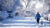 Una persona pasea con un perro por la calle South Pennsylvania después de que una tormenta invernal arrasara las montañas del oeste y arrojara hasta ocho pulgadas de nieve, el 29 de diciembre de 2022 en Denver, Colorado, EEUU.
