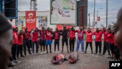 Des gens se tiennent sur une place publique à Goma tout en participant à des exercices sportifs le 20 novembre 2022