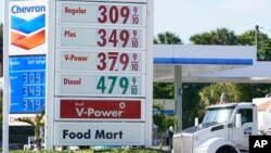 A Chevron and Shell gas station post the same prices for gasoline, Dec. 12, 2022, in Miami, Florida.