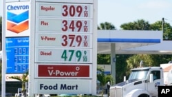 A Chevron and Shell gas station post the same prices for gasoline, Dec. 12, 2022, in Miami, Florida.