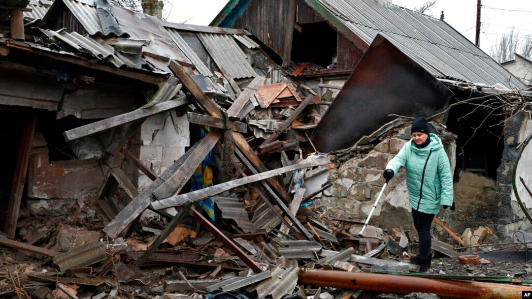 A woman stands near debris of her house following Russian shelling, in Kurakhove, Donetsk region, Ukraine, Dec. 8, 2022.