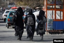 Mahasiswi Afghanistan berjalan di dekat Universitas Kabul di Kabul, 21 Desember 2022. REUTERS/Ali Khara