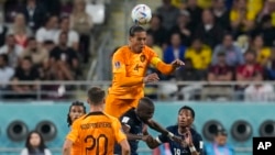 Virgil van Dijk of the Netherlands, top, outjumps Ecuador defenders to head the ball during a World Cup group A soccer match at Khalifa International Stadium in Doha, Qatar, Nov. 25, 2022.