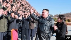 This undated photo provided on Nov. 27, 2022, by the North Korean government shows North Korean leader Kim Jong Un with his daughter waving to scientists and workers, following the launch of what it says a Hwasong-17 intercontinental ballistic missile.