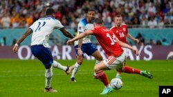 England's Marcus Rashford, left, scores past Wales' Connor Roberts for his side's third goal during the World Cup group B soccer match at Ahmad Bin Ali Stadium in Al Rayyan, Qatar, Nov. 29, 2022.