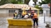 FILE - State Emergency Service (SES) personnel navigate floodwaters with residents and supplies aboard a watercraft at the town of Forbes, in the Central West region of New South Wales, Australia, November 16, 2022. 