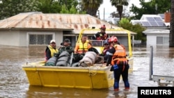 Sejumlah petugas tanggap darurat (SES) mengevakuasi warga dan barang-barang bawaan di sebuah kendaraan air di Kota Forbes, negara bagian New South Wales, Australia, 16 November 2022.
